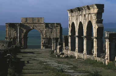 Portique sur le Decumanus Maximus et arc de triomphe de Caracalla